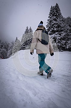 Winter sport activity, Woman hiker hiking with backpack on snow trail forest in Pyrenees, France