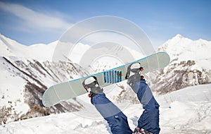 Winter sport concept with man on top of mountain ready to go down. legs on a snowboard in the background of the sky.
