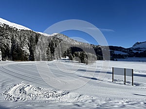 A winter sport cross-country ski trail around a frozen alpine Heidsee lake (Igl Lai lake) in the Swiss winter resorts