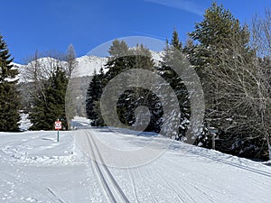 A winter sport cross-country ski trail around a frozen alpine Heidsee lake (Igl Lai lake) in the Swiss winter resorts