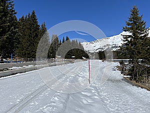 A winter sport cross-country ski trail around a frozen alpine Heidsee lake (Igl Lai lake) in the Swiss winter resorts