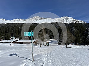 A winter sport cross-country ski trail around a frozen alpine Heidsee lake (Igl Lai lake) in the Swiss winter resorts