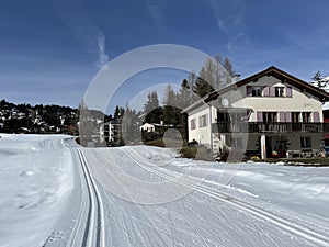 A winter sport cross-country ski trail around a frozen alpine Heidsee lake (Igl Lai lake) in the Swiss winter resorts