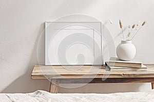 Winter still life. Horizontal white frame mockup on vintage wooden bench, table. Modern white ceramic vase with pine