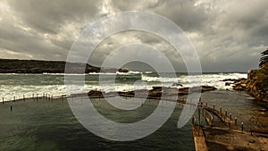 Winter storm waves crashing rocks tidal pool storm clouds