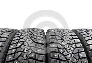 Winter studded tire. Winter car tires isolated on white background. Tire stack background. Tyre protector close up. Square