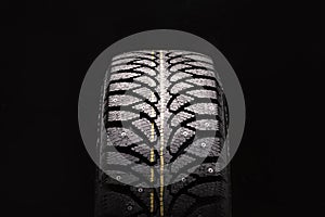 winter studded tire new photo from the front on a black background close-up