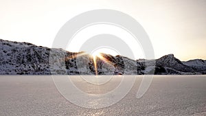 Winter sun on frozen lake on road to Laukvik on the Lofoten in Norway