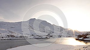 Winter sun on frozen lake on road to Laukvik on the Lofoten in Norway
