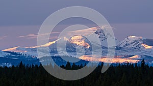 A winter sun sets over the Cascade Mountain Range in Oregon