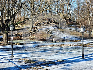 Winter sunny day in Bastion Park with remaining ice on the ground in anticipation of spring, Riga