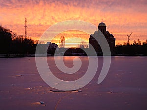 Winter sunrise on a city lake with the church