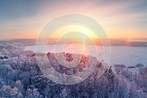 Winter sunrise. Winter forest with frost. Aerial winter landscape.