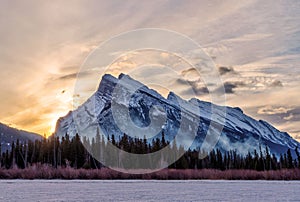 Winter sunrise over frozen Vermilion Lakes covered in snow at Banff National Park