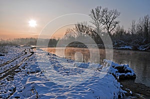 Winter sunrise over snowy river