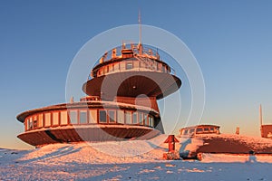 Winter, sunrise time, disc shaped meteorological observatory in snezka, mountain on the border between Czech Republic and Poland