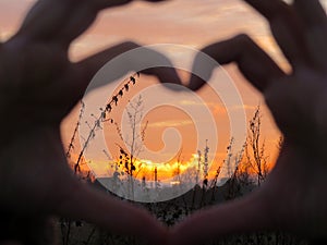 Winter sunset in the heart of hands