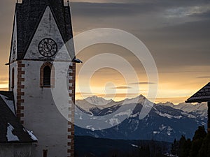 Winter sunset landscape of an old austrian church in an alps village, snowy mountains, Wallfahrtskirche Maria Schnee Matzelsdorf