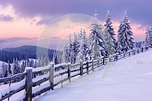 Winter Sunset Over Snow-Covered Pine Trees and Wooden Fence in Mountain Landscape