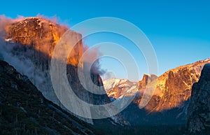 winter sunset shot of yosemite's el capitan and half dome as storm clouds clear from yosemite national park