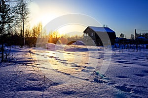 Winter sunset village in cold evening. Russian winter.