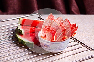 Winter supplies: slices of dried watermelon with fresh pieces on light background with grid