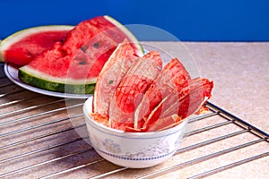 Winter supplies: slices of dried watermelon with fresh pieces on light background with grid