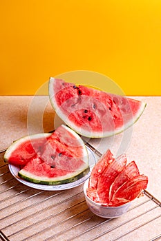 Winter supplies: slices of dried watermelon with fresh pieces on yellow background