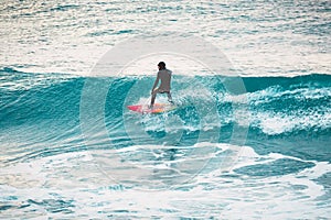 Winter surfing in ocean. Surfer on blue wave