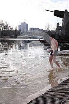 Winter swimming in ice water. January weather, Epiphany frosts and a man bathing.