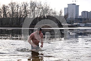 Winter swimming in ice water. January weather, Epiphany frosts and a man bathing.