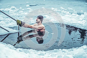 Winter swimming. Man in an ice-hole.