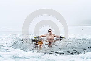 Winter swimming. Man in an ice-hole.