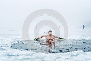 Winter swimming. Man in an ice-hole.