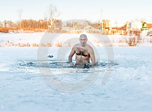 Winter swimming. Man in ice-hole