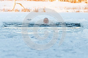 Winter swimming. Man to an ice-hole