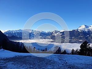 Winter in the swiss alps, Switzerland. Panoramic view. Snowy winter landscape in the mountains with fir trees and wooden fence.