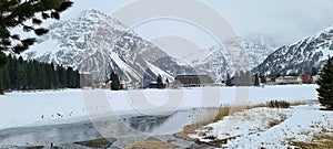 Winter in the swiss alps, Switzerland. Panoramic view. Snowy winter landscape in the mountains with fir trees and wooden fence.