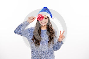 Winter teenager girl with christmas lollipop. Christmas teen girl. Portrait of teenager in winter sweater isolated over