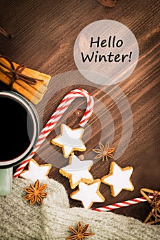 Winter theme. Hot steaming cup of glint wine with spices, cinnamon, anise, cookies in a shape of star, red candies, pepper and