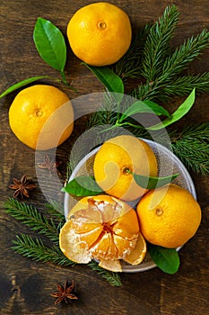 Winter time fruits. Fresh juicy clementine mandarins with leaves on rustic wooden table.