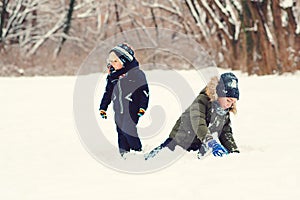 Winter time. Happy kids playing outdoors with snow. Little brothers aving fun in winter park. Happy and healthy childhood. Winter