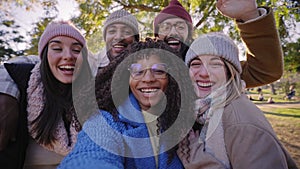 Winter time smiling selfie of a happy group of multicultural friends video call