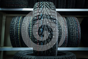 Winter tire on the background of racks with tires