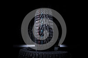 Winter tire on the background of racks with tires