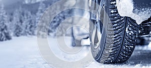 Winter tire. Detail of car tires in winter on the road covered with snow. Panorama  banner.