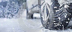 Winter tire. Detail of car tires in winter on the road covered with snow. Panorama  banner.