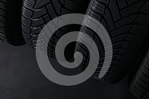 Winter tires on dark background, closeup. Space for text