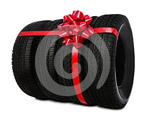 Winter tires with red ribbon on white background