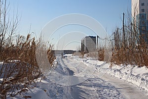 Winter track road high apartment buildings in the city drive through the wasteland